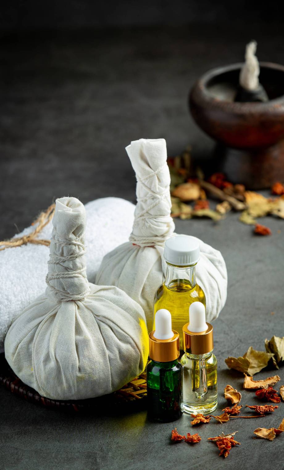 Herbal compress and herbal spa treatment equipments put on dark floor